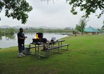 Man BBQing by a lake in Prado Regional Park